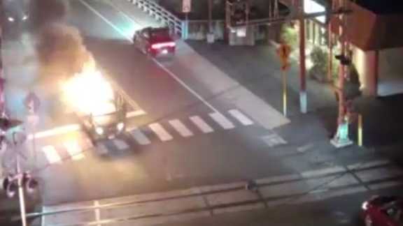 Video shows man running toward burning car to save person trapped inside